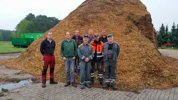 Team von Friedrich Lange vor einem Haufen mit Rindenmulch