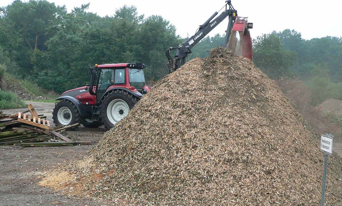 Traktor vor Berg mit Hackschnitzeln
