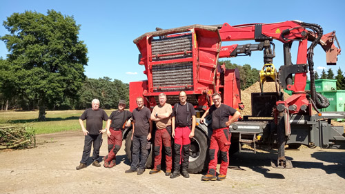 Team von Friedrich Lange vor einem Haufen mit Rindenmulch